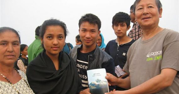 Nepali evangelist Timothy Rai giving away Bible