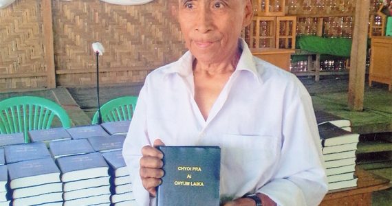 Man from Myanmar holding Bible he received from the Strategic Bibles Ministry