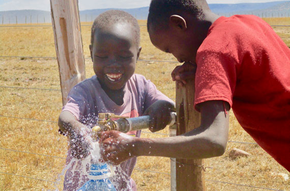 Child in Africa enjoying safe drinking water