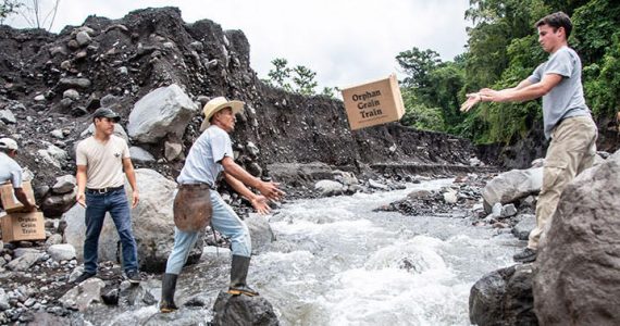 Picture of relif team throwing emergency supplies across river in Guatemala