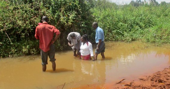 Picture of woman in Kenya being baptized in muddy water