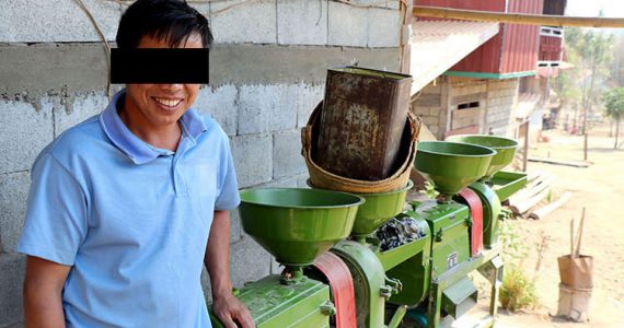 Picture of borrower with rice hulling machine