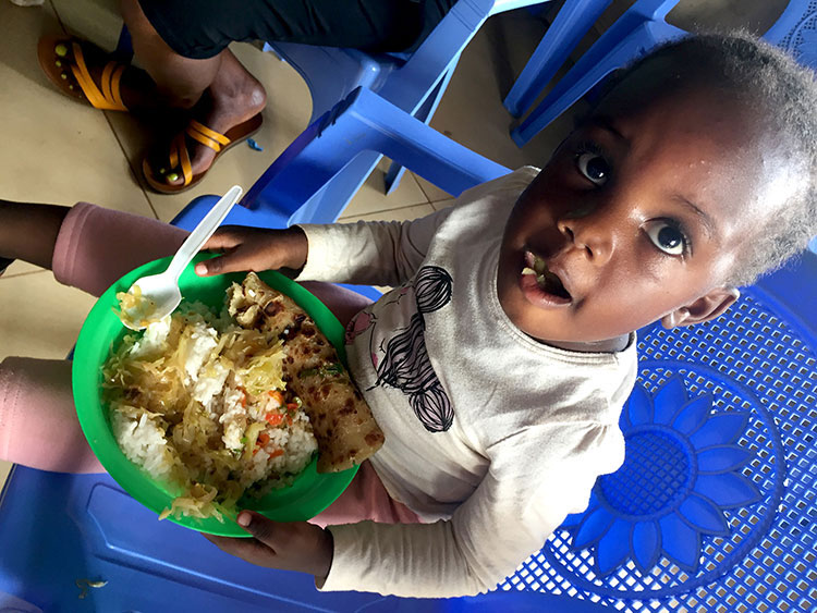 Image of child in Kibera, Kenya receiving food